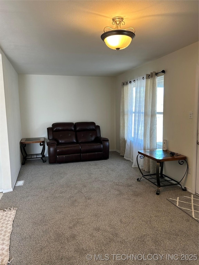 carpeted living area with baseboards