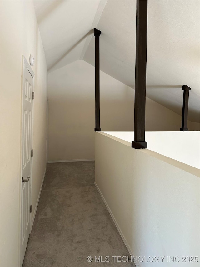 corridor with baseboards, lofted ceiling, and carpet floors