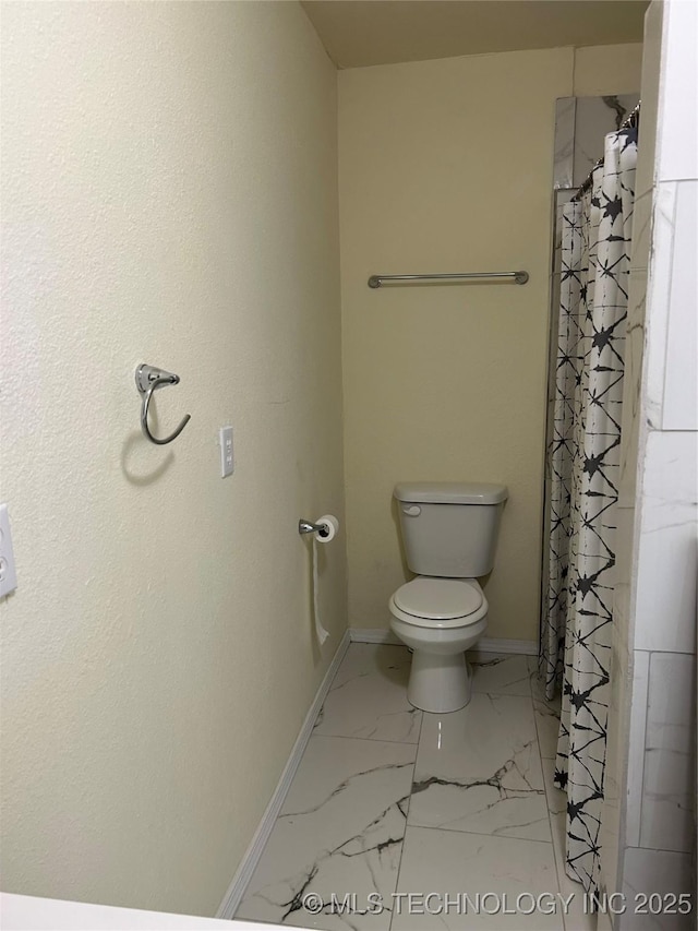 full bath featuring a shower with curtain, marble finish floor, toilet, and baseboards