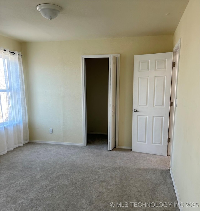 unfurnished bedroom with baseboards and carpet flooring