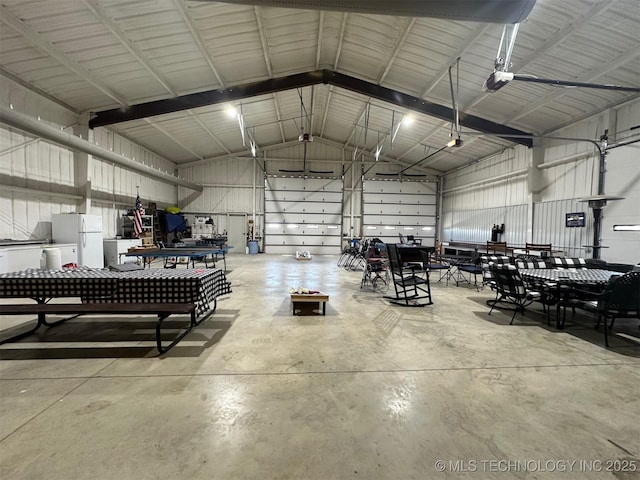 garage featuring metal wall and freestanding refrigerator