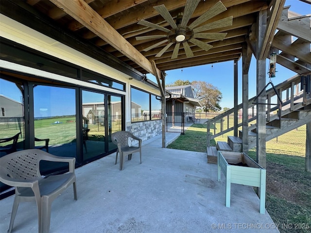 view of patio / terrace featuring stairs, fence, and ceiling fan