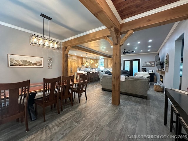 dining room featuring beam ceiling, dark wood-type flooring, a fireplace, and crown molding