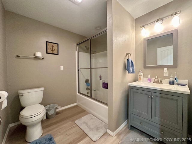 bathroom featuring toilet, vanity, baseboards, and wood finished floors