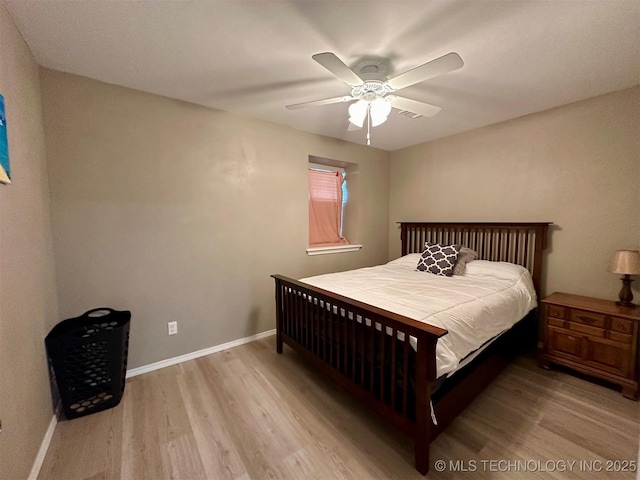 bedroom featuring baseboards, wood finished floors, and a ceiling fan