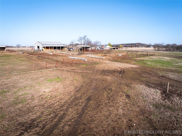 view of yard with an outbuilding, a rural view, and fence