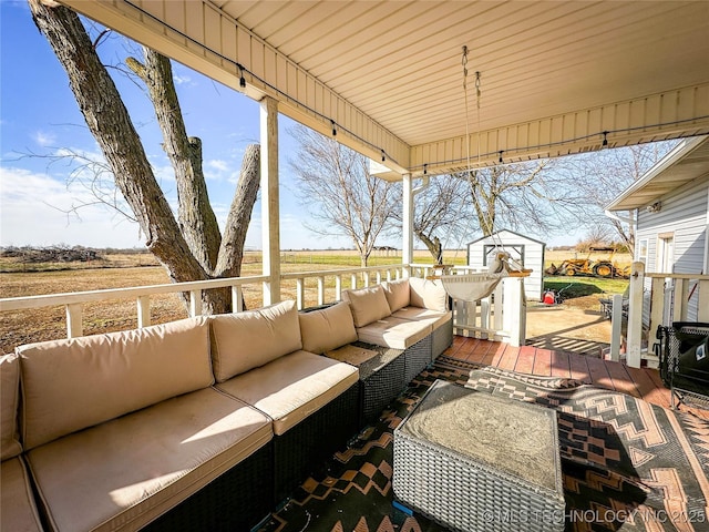 view of patio with a rural view, an outdoor hangout area, a storage shed, and an outdoor structure