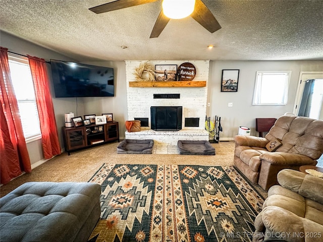 carpeted living room featuring a ceiling fan, a fireplace, baseboards, and a textured ceiling