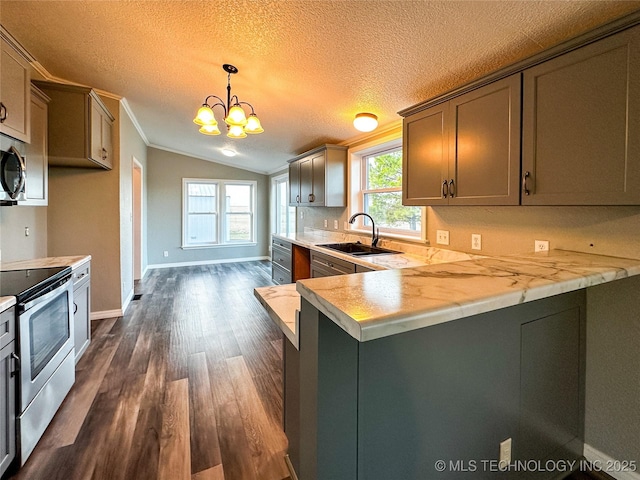 kitchen featuring light countertops, vaulted ceiling, appliances with stainless steel finishes, and a sink