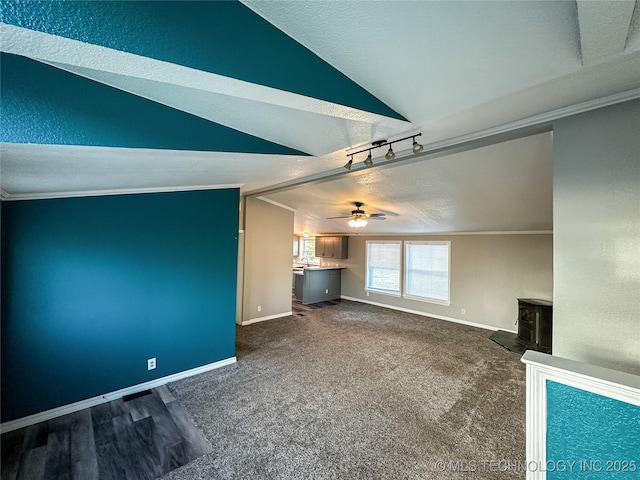 unfurnished living room with baseboards, crown molding, and lofted ceiling