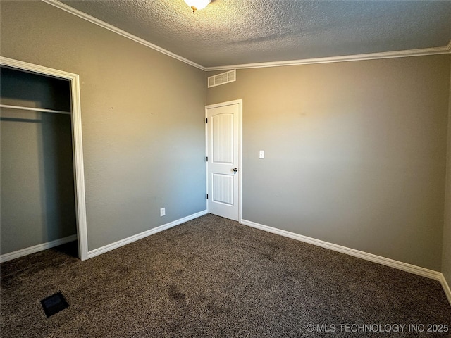 unfurnished bedroom featuring baseboards, visible vents, carpet floors, ornamental molding, and a textured ceiling