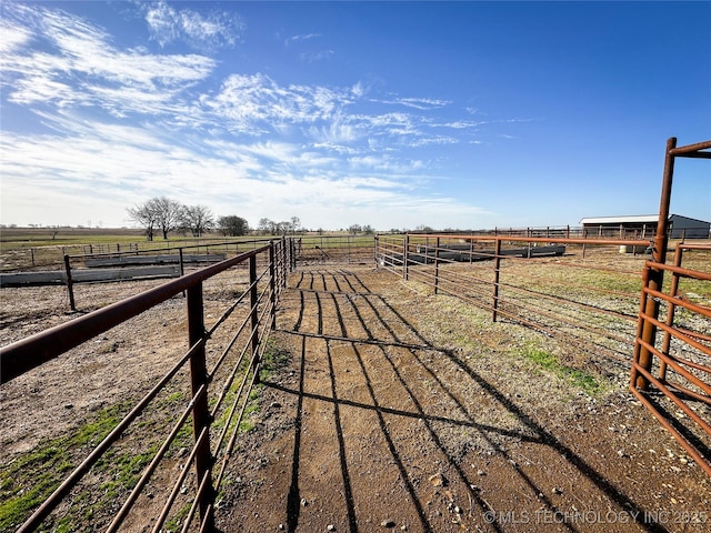 view of yard with an exterior structure, a rural view, and an outdoor structure