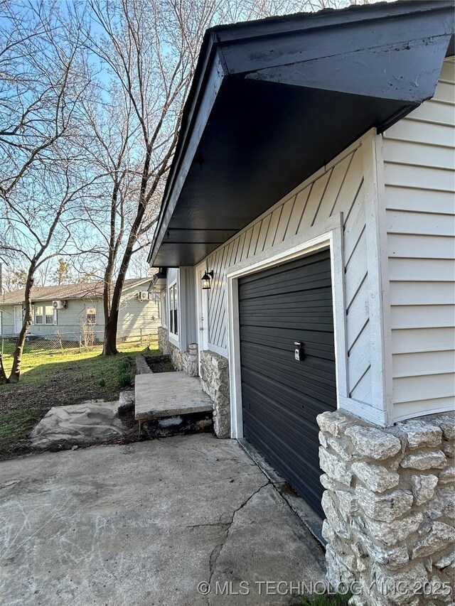 339 W 62nd St N, Tulsa, OK 74126 - view of side of home featuring stone siding and concrete driveway