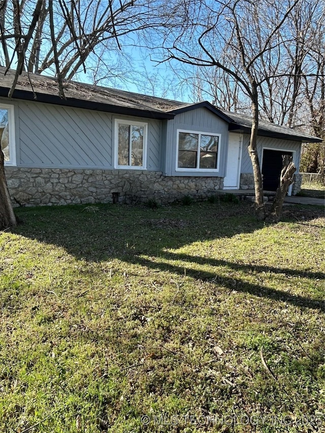 339 W 62nd St N, Tulsa, OK 74126 - view of front facade featuring stone siding, a garage, and a front yard