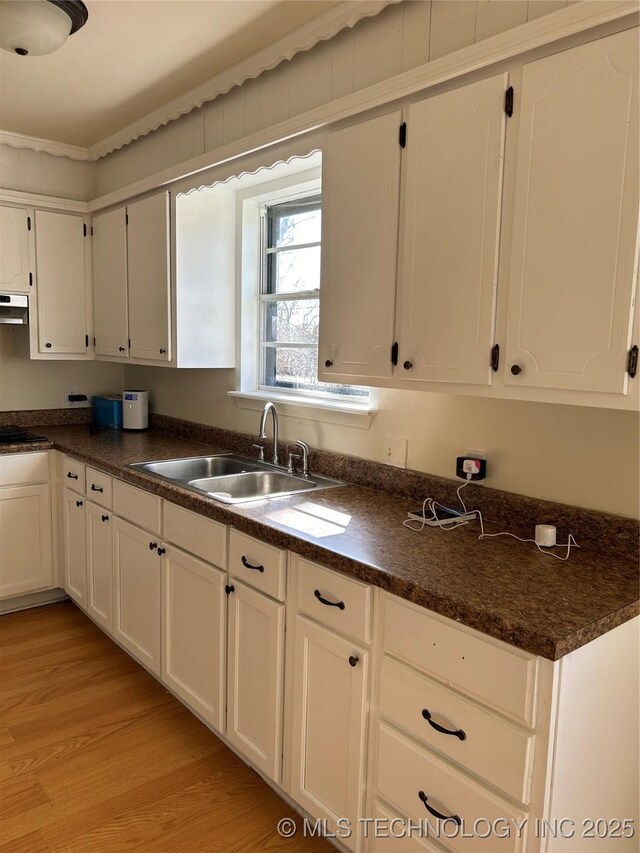 339 W 62nd St N, Tulsa, OK 74126 - kitchen featuring a sink, dark countertops, stovetop, light wood-style floors, and white cabinets