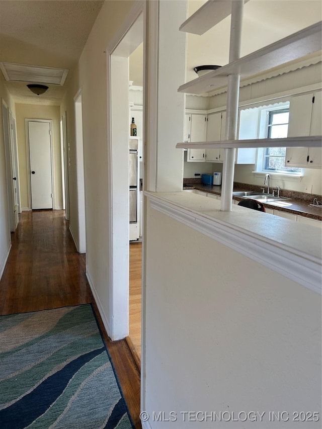 339 W 62nd St N, Tulsa, OK 74126 - corridor featuring wood finished floors, baseboards, and a sink