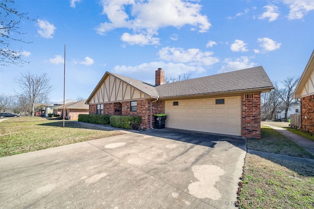 tudor home with brick siding, driveway, and a garage