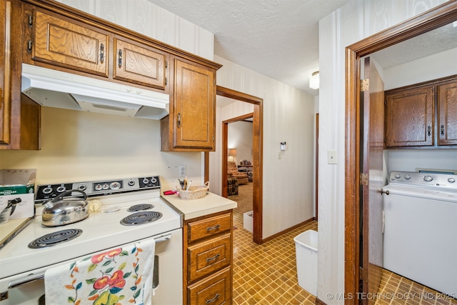 kitchen with brown cabinetry, washer / dryer, light countertops, electric stove, and under cabinet range hood