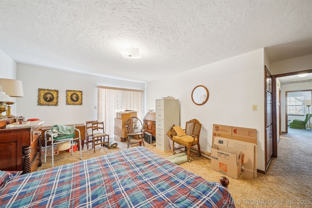 bedroom with baseboards, carpet, and a textured ceiling