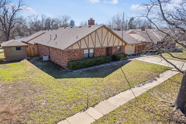 view of property exterior with brick siding, a lawn, a chimney, a garage, and driveway