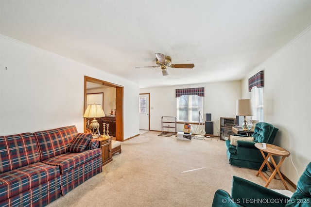 living room featuring baseboards, carpet, ceiling fan, and ornamental molding