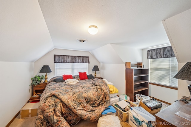 carpeted bedroom with visible vents, baseboards, a textured ceiling, and vaulted ceiling