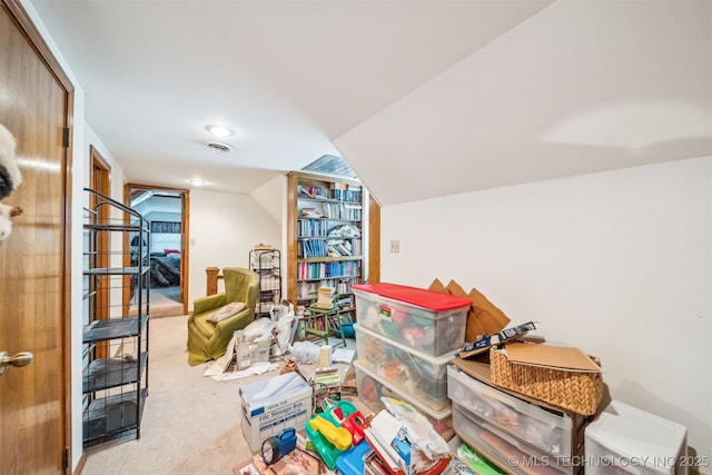 interior space featuring lofted ceiling, visible vents, and carpet floors