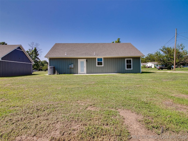 back of property with cooling unit and a lawn