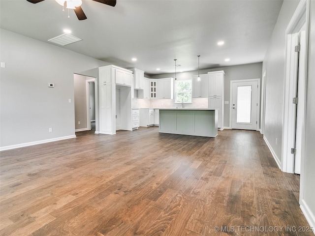 unfurnished living room with visible vents, recessed lighting, baseboards, and wood finished floors