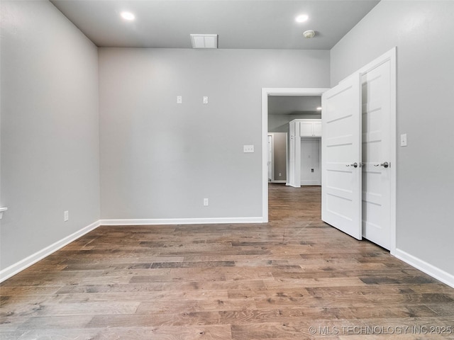 unfurnished room featuring recessed lighting, baseboards, and wood finished floors