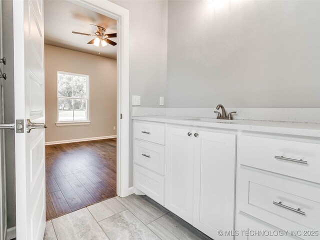 bathroom with vanity, wood finished floors, baseboards, and ceiling fan