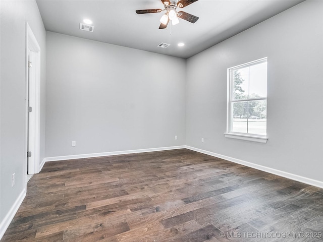 empty room featuring visible vents, baseboards, dark wood-type flooring, and a ceiling fan