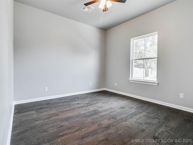 spare room featuring visible vents, baseboards, ceiling fan, and dark wood-style flooring