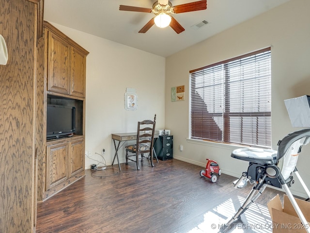 home office featuring dark wood-style floors, visible vents, baseboards, and ceiling fan