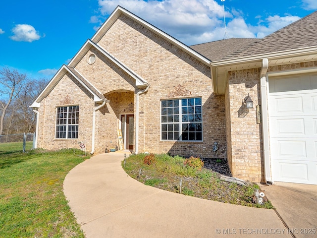 ranch-style house featuring brick siding, an attached garage, a front yard, and fence