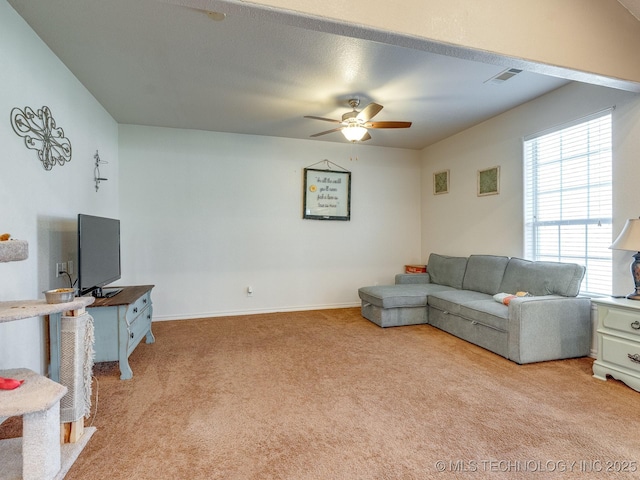 living room featuring visible vents, baseboards, light colored carpet, and a ceiling fan