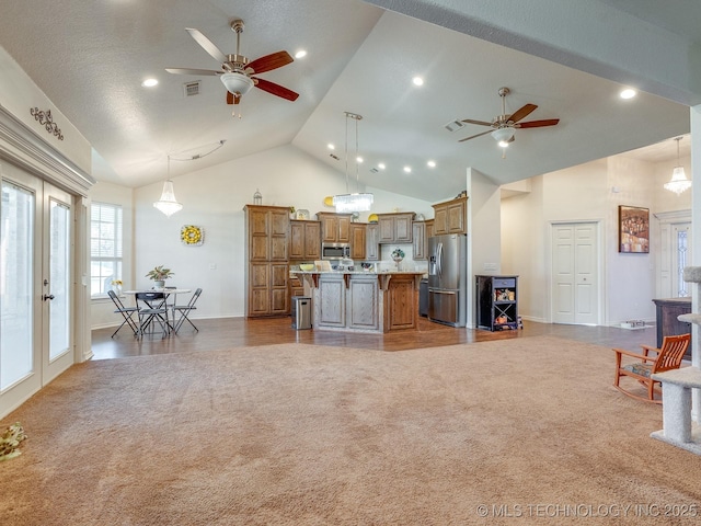 kitchen with visible vents, carpet, open floor plan, and stainless steel appliances