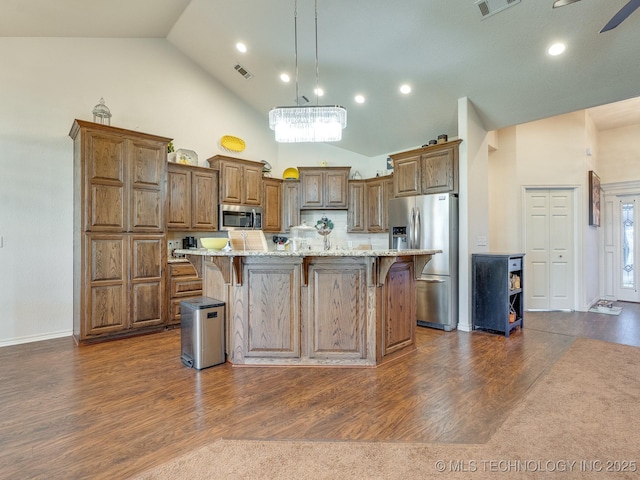 kitchen featuring a kitchen breakfast bar, visible vents, dark wood-style flooring, and stainless steel appliances