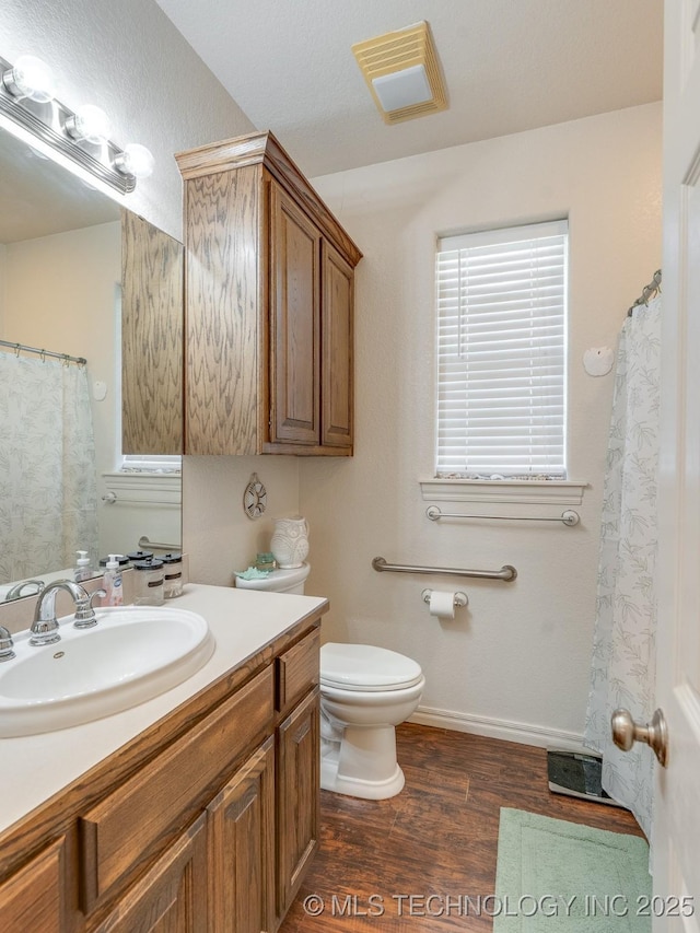 bathroom featuring visible vents, toilet, wood finished floors, and vanity