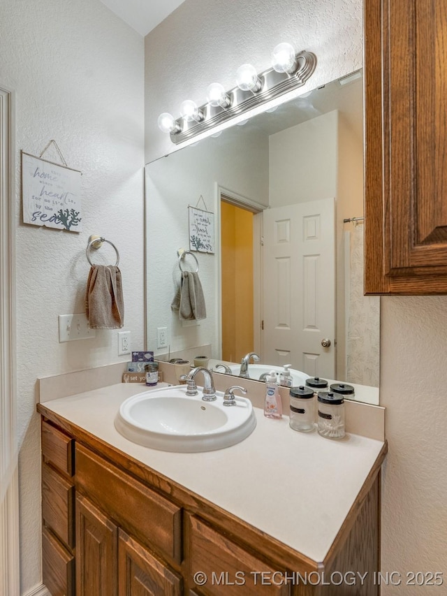 bathroom featuring vanity and a textured wall