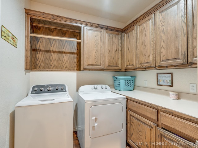 clothes washing area featuring cabinet space and independent washer and dryer