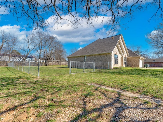 view of yard featuring a garage, fence, and a gate