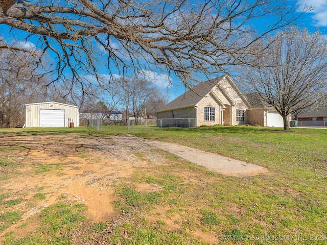 view of yard featuring an outbuilding, driveway, a garage, and fence