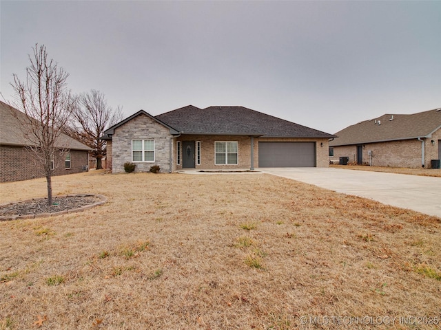 ranch-style home with an attached garage, concrete driveway, a front yard, and a shingled roof