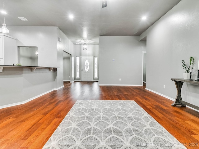 foyer featuring visible vents, baseboards, and wood finished floors