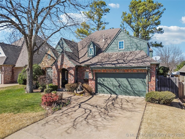 view of front of home featuring brick siding, a front lawn, fence, concrete driveway, and a garage