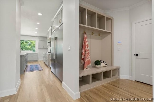 mudroom with recessed lighting, baseboards, and light wood-type flooring