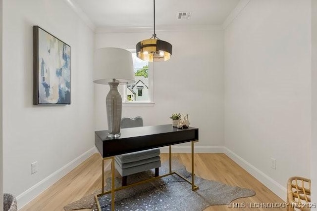 office featuring visible vents, baseboards, wood finished floors, and crown molding