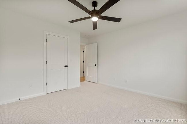 unfurnished room with baseboards, light carpet, and ceiling fan