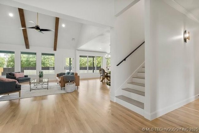 living room with beam ceiling, stairway, high vaulted ceiling, and wood finished floors